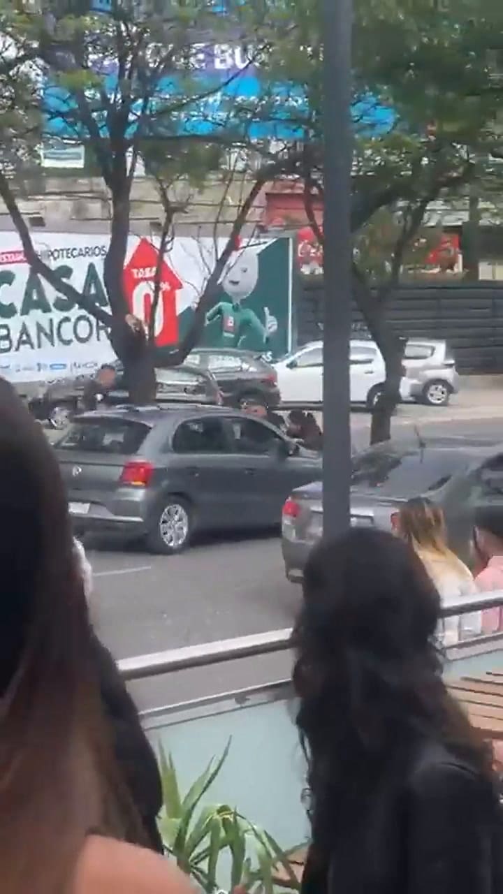 El gesto de desesperación de dos policías mientras son arrastrados en el capot de un automóvil