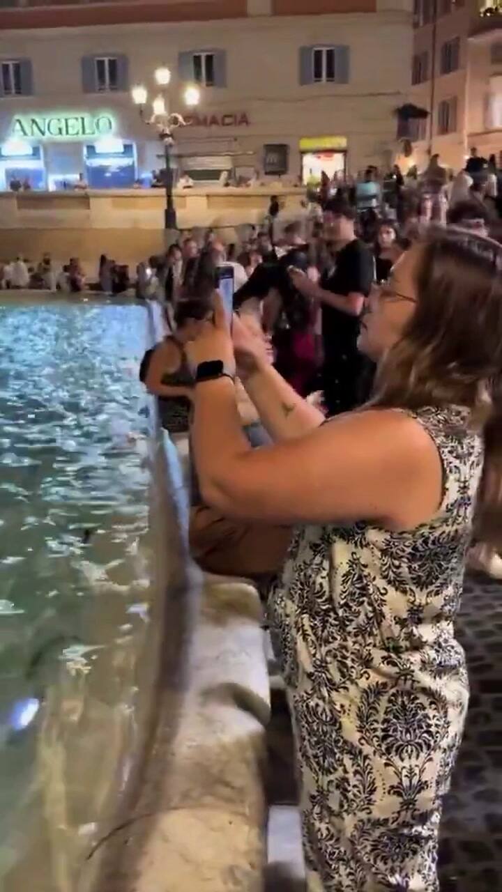 El momento en que la turista mete los pies en la Fontana di Trevi