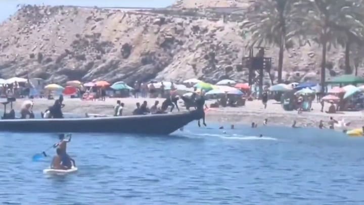 Videos: un grupo de inmigrantes desembarcó en una playa española y fue detenido con ayuda de bañistas