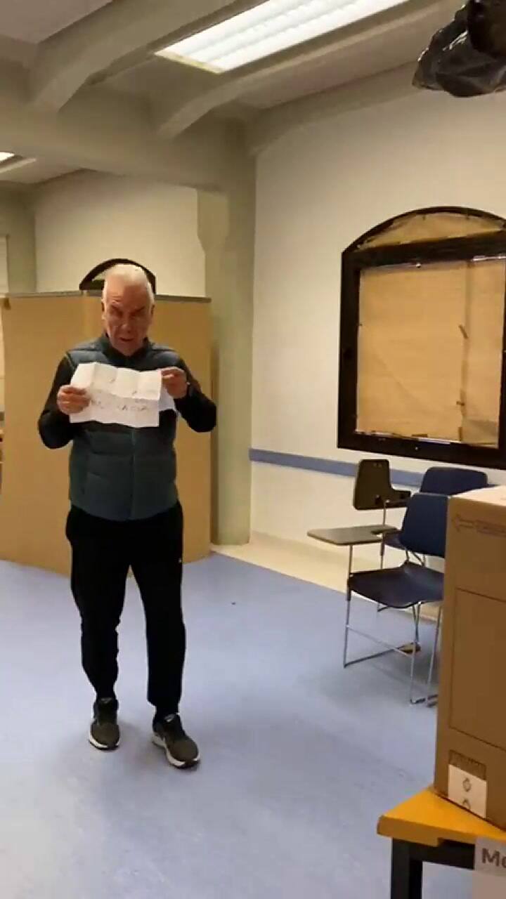 Esteban Mirol mostró un cartel antes de depositar su voto en la urna