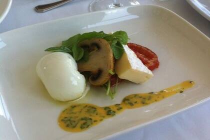 Huevo poche con brie, rúcula, hongos y tomates confitados