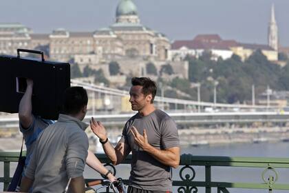 Hugh Jackman charla con integrantes del equipo de filmación en 2011, en el puente Szabadsag de Budapest