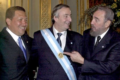 Todo sonrisas. Hugo Chávez, Néstor Kirchner y Fidel Castro en la asunción del presidente argentino, en 2003. La buena sintonía entre los tres marcó la relación política y económica.