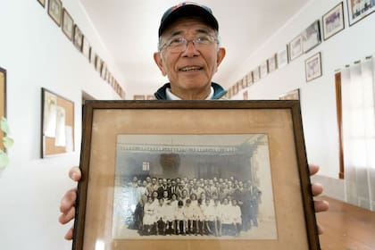 Humberto Koike sostiene una vieja foto de la escuela japonesa de Escobar