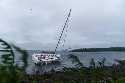 Un velero varado en la costa después de soltarse de su amarre cuando la tormenta tropical Henri pasó por el área en Jamestown, Rhode Island, el domingo 