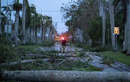 Un hombre camina entre los escombros en una calle tras el paso del huracán Ian en Punta Gorda, Florida