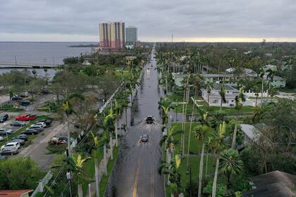 En esta vista aérea, los vehículos se abren paso a través de una zona inundada después de que el huracán Ian pasara por la zona de Fort Myers, Florida