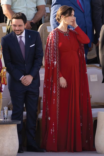 Hussein, el príncipe heredero, con su mujer Rajwa, quien lució una creación –un vestido con capa, ambos con bordados y detalles
de pedrería– de la jordana Honayda. Al igual que el diseño, al estilo tradicional jordano, la elección del color no fue casual: lleva los colores de la bandera de ese país.