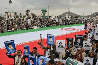 Hutíes sostienen carteles del líder supremo de Irán, junto a una enorme bandera iraní mientras protestan contra la guerra contra Irán, en Saná, Yemen, el viernes 6 de marzo