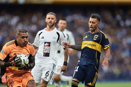 Ignacio Arce, arquero de Riestra, controla la pelota ante la mirada de Lucas Janson; el delantero que jugó de 9 no tuvo un buen partido