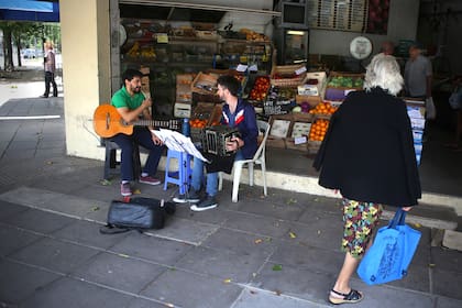 Ignacio y Adrián tocan tango, mientras llegan los clientes a la verdulería de Bahía Blanca y Beláustegui