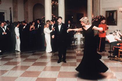 Imagen histórica de 1985: ante el asombro de los invitados, Diana Spencer con John Travolta en la Casa Blanca. “Yo era consciente de que todo el mundo estaba mirándonos en ese momento, así que tomé su mano para que se sintiera segura de sí misma”, dijo el actor después de bailar con la princesa “You Should be Dancing”, tema de la película "Fiebre del sábado por la noche".