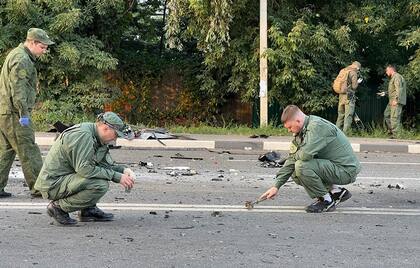 Imagen tomada de un video publicado por el Comité de Investigación ruso el domingo 21 de agosto de 2022, en la que los investigadores trabajan en el lugar de la explosión