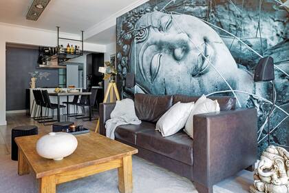 Impactante, el mural hecho a medida por Enamorada del Muro. Alfombra (Missha Deco). Sobre la mesa de centro, obra en cerámica artesanal (Marianne Alonso) y bandeja de mármol (Melgar Mármoles) con vela en envase de vidrio negro (Bohemia Velas).