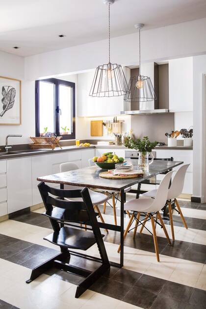 Impactante, la mesa de hierro (Estudio Tomas Magrane) se destaca y le da un carácter entre industrial y rústico a este ambiente de líneas puras. Lámparas colgantes traídas de Roma.