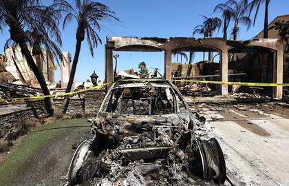 Un Porsche quemado se sienta afuera de una de las más de 20 casas destruidas por el incendio costero el 12 de mayo de 2022 en Laguna Niguel, California