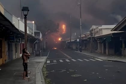 Una persona observa una área comercial que fue evacuada por la proximidad del fuego