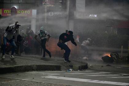 Incidentes de manifestantes contra la policía en cercanías del estadio Romelio Martínez, de Barranquilla; la violencia política convenció a Conmebol de quitarle a Colombia su 50% de la sede de la Copa América; sin embargo, en aquella ciudad actuará el seleccionado argentino por la eliminatoria para el Mundial de Qatar.