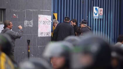 La policía rompe las cerrdauras de unos de los portones para ingresar a la fábrica