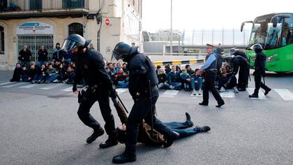 Policías regionales catalanes (Mossos d'Esquadra) arrastran a un piquetero que bloquea la calle en la estación de autobuses Norte de Barcelona