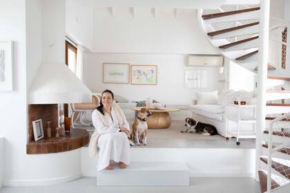 Ingrid Hajnal, creadora de The Organization Wiz, con sus perros Adi y Sam, en el living de su casa “Me interesaba conservar rasgos años 70 como la chimenea, el desnivel, la doble altura, la escalera caracol y un mueble de obra. Pero les hicimos cambios para lograr coherencia general”.