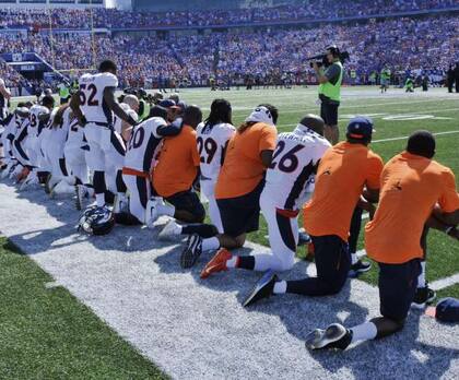 Integrantes de los Denver Broncos se arrodillaron anteayer durante el himno