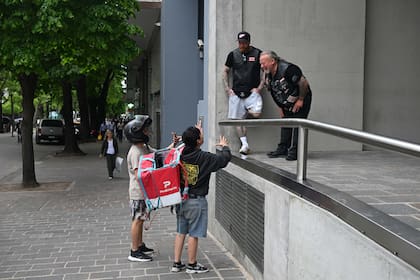 Integrantes de los Hell’s Angels conversan con dos repartidores