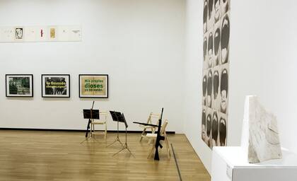 Intermedi, tres atriles de música con ametralladoras, de Brossa, confronta con Roberto Jacoby en la pared