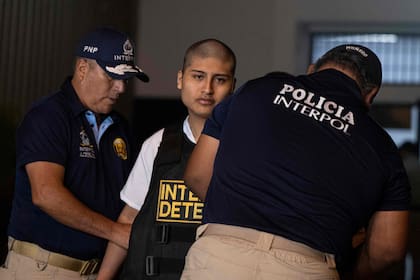 Interpol officers place a bulletproof vest on Tony Janzen Valverde Victoriano, alias "Pequeno J", as they escort him away after he was handed over by agents of the National Penitentiary Institute (INPE) outside the Ancon II penitentiary, in Lima, on May 4, 2026. Peru' National Penitentiary Institute (INPE) said on May 5 that it handed over Tony Janzen Valverde Victoriano, alias "Pequeno J", to Interpol in compliance with an order issued by the Attorney Generals Office of International Judicial Cooperation and Extraditions, as he is wanted by Argentine authorities. (Photo by ERNESTO BENAVIDES / AFP)