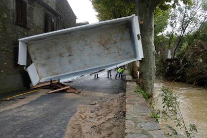 El acoplado de un camión quedó atascado entre una pared y un árbol