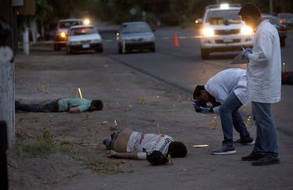 Investigadores sacan fotos de la escena del crimen en Navolato, Sinaloa