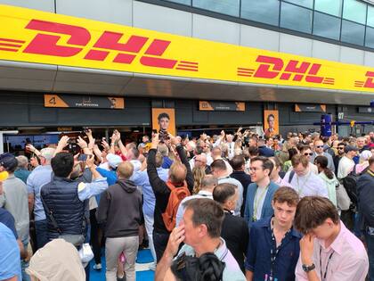 Invitados y espectadores con pases vip recorren el pit-lane de Silverstone antes de la qualy del sábado