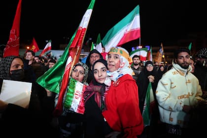 Iraníes reaccionan tras el anuncio de un alto el fuego en la plaza Enqelab, en Teherán, el 8 de abril de 2026