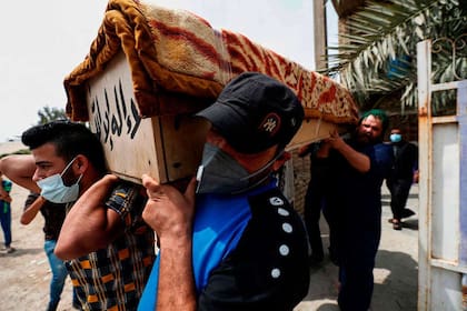 Iraquíes transportan el ataúd de un familiar que murió durante la explosión registrada ayer en el hospital Ibn Al Khatib en Bagdad