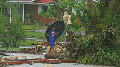 Aden Alcroix-Camper, de 11 a?os, camina a través de los escombros de un tejado en en Palm Bay, Florida