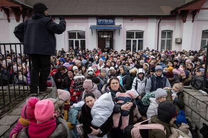 Un miembro del ejército ucraniano da instrucciones a mujeres y niños que huyeron de los combates en Bucha e Irpin