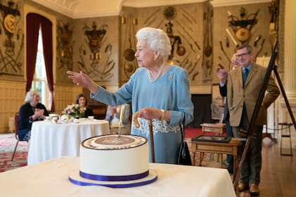 Isabel II corta una torta al inicio del aniversario de platino de su reinado, este año, en la residencia de Sandringham
