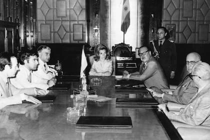 Isabel Perón, durante una reunión de gabinete, en 1975. A su derecha se observa a Carlos Ruckauf y a Antonio Cafiero 