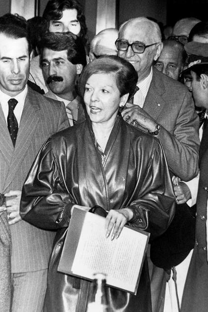 Isabel Perón durante su primera visita a Buenos Aires tras la asunción de Alfonsín; detrás, el expresidente Arturo Frondizi