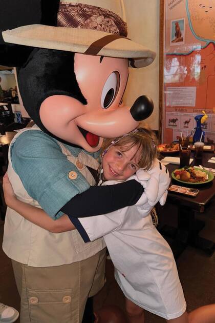 Isabella abraza a Mickey Mouse.