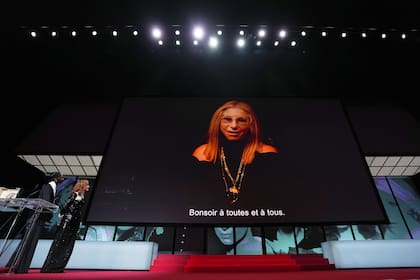 Isabelle Huppert observa en el gigantesco escenario de Cannes el mensaje de agradecimiento enviado por Barbra Streisand por la Palma de Oro honoraria que recibió este año