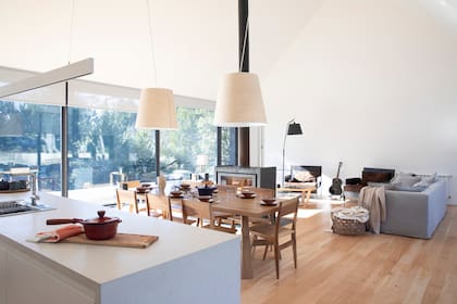 Isla de cocina, comedor y living integrados. Sillón gris (Eugenio Aguirre).