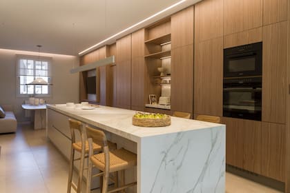 Isla de Neolith 'Calacatta' con terminación Silk (Destefano por United Stone). Baquetas 'Moller' (Navarro Hábitat). Lámpara de techo (World Leds Go por Griscan). Al bajar el cielo raso, dejaron ranuras en las que embutiero tiras LED.