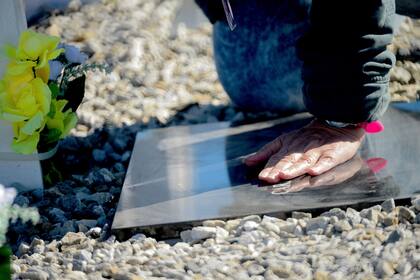 Familiares de los caídos tocan las placas que por primera vez son identificadas