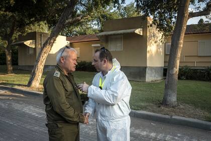 Israel Ziv, un general retirado del Ejército Israelí, conversando con el jefe de medicina forense en el kibutz Be'eri, en Israel el 11 de octubre de 2023.
