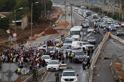 Israelíes marchan en una carretera de Tel Aviv hacia el parlamento israelí en Jerusalén el 14 de noviembre de 2023, como parte de una protesta por la liberación de israelíes retenidos por militantes palestinos desde el ataque del 7 de octubre.