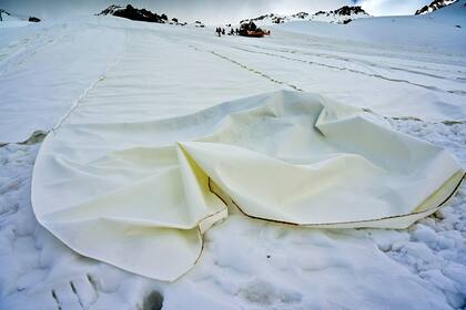 Una inmensa tela blanca recubre el flanco de una montaña del Valle del Sol, en el norte de Italia, para proteger el glaciar de Presena del calor, como si se tratara de una inmensa obra del artista recientemente fallecido Christo