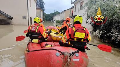 Esta foto tomada y distribuida como folleto el 17 de mayo de 2023 por Vigili del Fuoco, el Cuerpo de Bomberos de Italia, muestra a los bomberos en un bote buscando posibles personas en peligro en una calle inundada en Faenza, región de Emilia-Romagna.