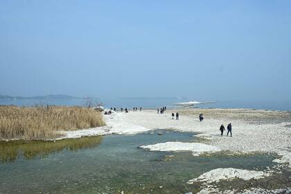 Los turistas caminan por el lecho del río Garda.