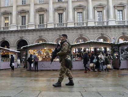 Italia. Un soldado frente al mercado en la plaza del Duomo, Milán